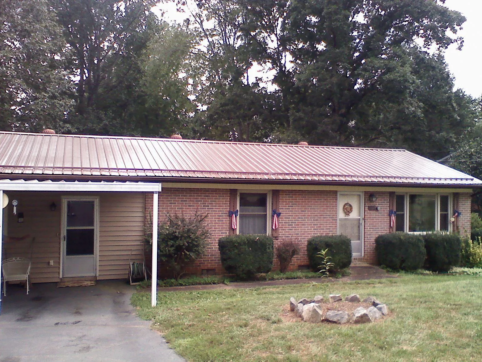 Bronze metal roof and carport on a brick ranch home — Roof Repair work by our crew in Jourdanton