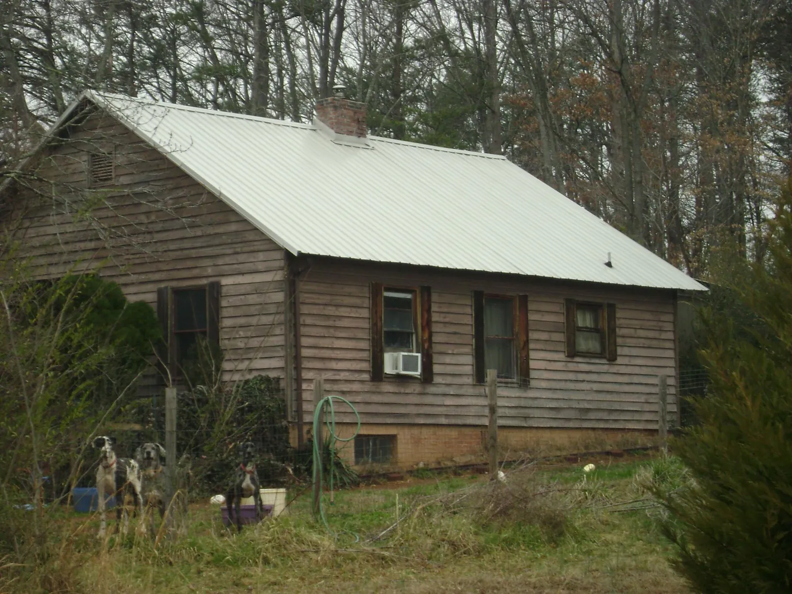 White metal roof on an old wood sided farmhouse, from a Metal Roof Installation job in Jourdanton